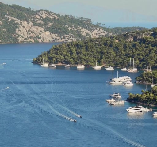 Mediterrane Bucht mit bewaldeten Inseln und Yachten